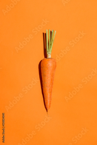 Leinwand Poster Top view of an carrot on orange background.