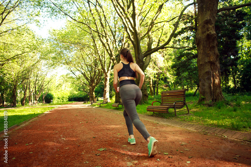 Young woman exercising running in summer park