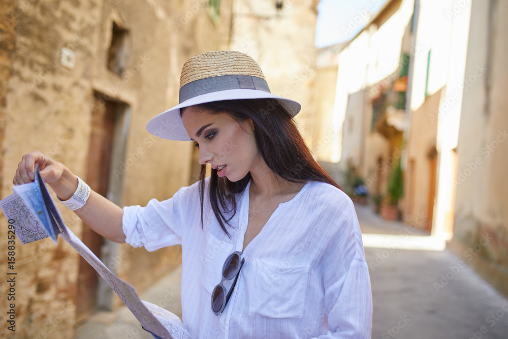 Tourist woman with a map in a small Italian town