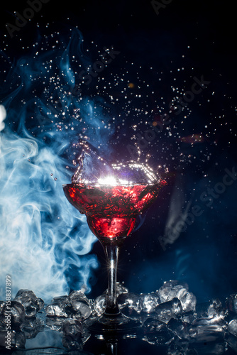 red cocktail with ice vapor, blue background