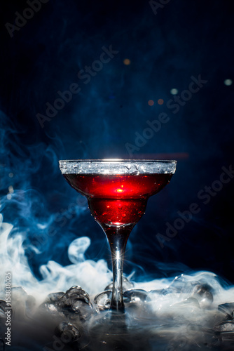 red cocktail with ice vapor, blue background