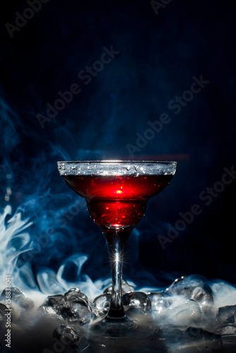 red cocktail with ice vapor, blue background
