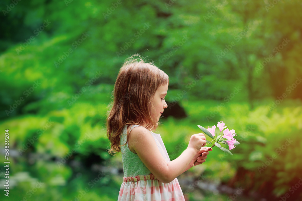 Little girl play with branch of flower Little girl play with branch of flower