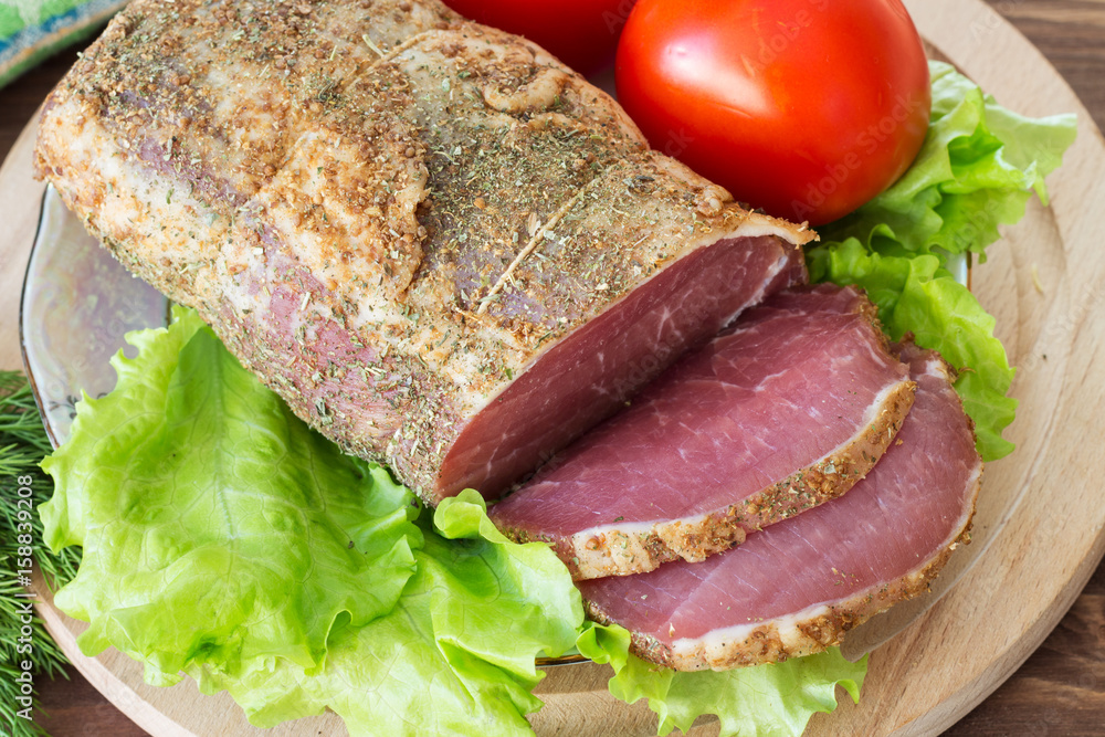 Slices of bacon and fresh lettuce and tomatoes on a wooden board. Selective focus. Slices of bacon and fresh lettuce and tomatoes on a wooden board. Selective focus.