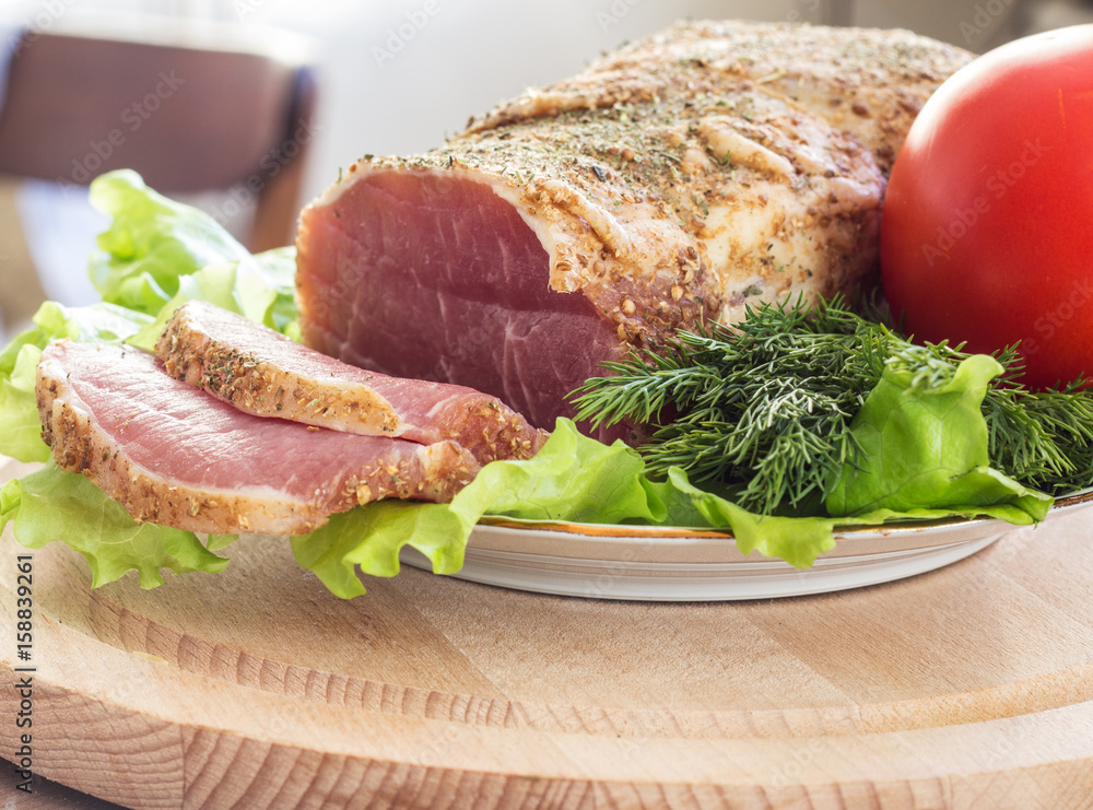 Slices of bacon and fresh lettuce and tomatoes on a wooden board. Selective focus. Slices of bacon and fresh lettuce and tomatoes on a wooden board. Selective focus.