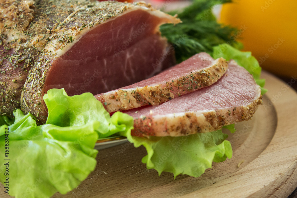 Sliced bacon and lettuce on a wooden plate. Selective focus. Sliced bacon and lettuce on a wooden plate. Selective focus.