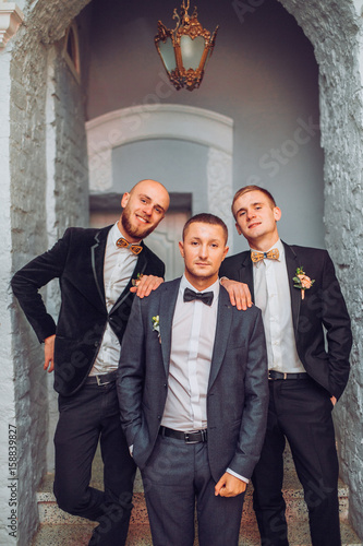 Joyful groom and his funny friends photo