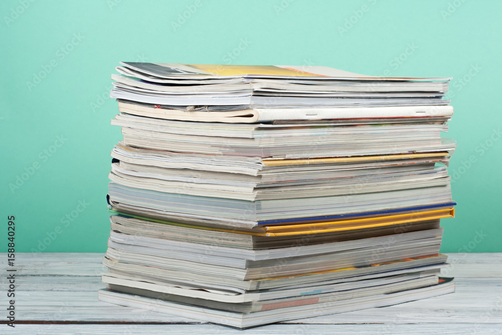 Open stacking book, magazine hardback colorful books on wooden table and green background. Back to school. Copy space for text. Education business concept. Open stacking book, magazine hardback colorful books on wooden table and green background. Back to school. Copy space for text. Education business concept.