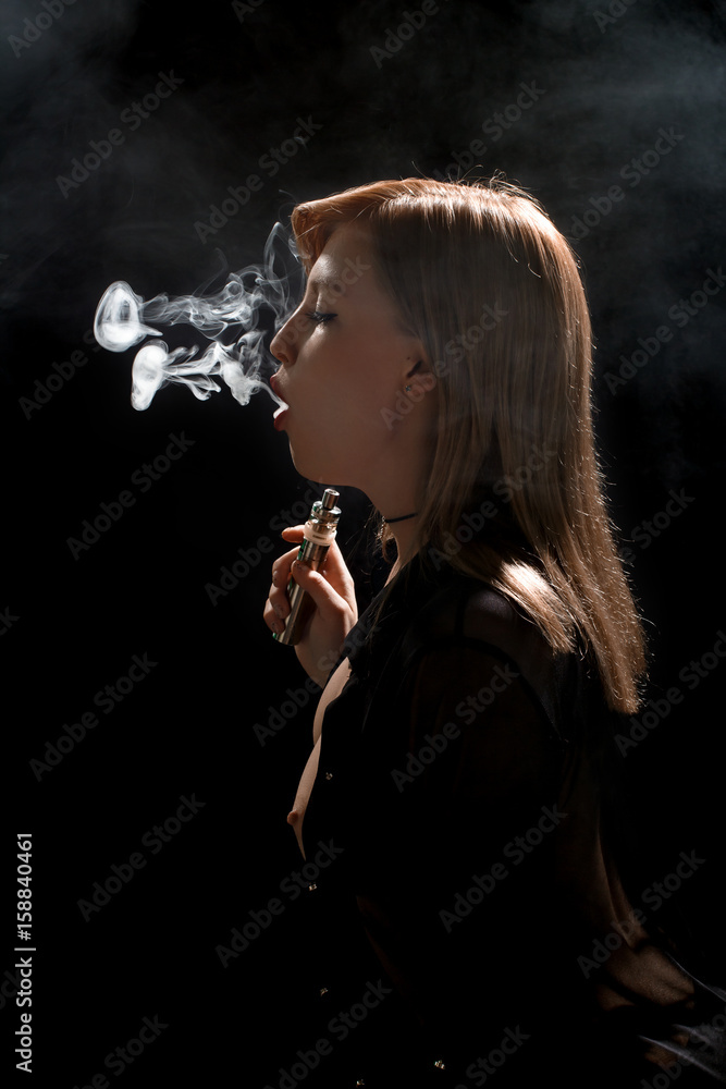 Fototapeta premium Beautiful girl vaping from e-cigarette.