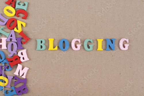 BLOGGING word on wooden background composed from colorful abc alphabet block wooden letters, copy space for ad text. Learning english concept.