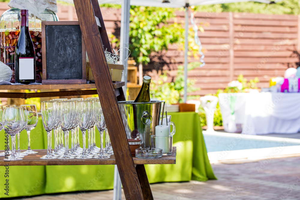Composition of catering stand with glasses, bottlesand other prepared for outdoor party. Composition of catering stand with glasses, bottlesand other prepared for outdoor party.