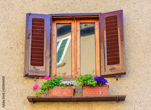 Frame of an italian window with flower pots in spring