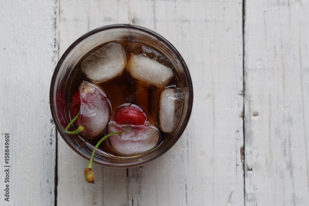 Cherry cola, ice cubes and cherry's in cola on white background Cherry cola, ice cubes and cherry's in cola on white background
