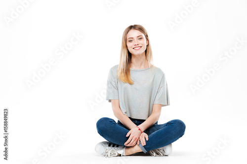 Young woman sitting cross-legged isolated