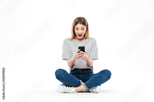 Surprised woman using smartphone