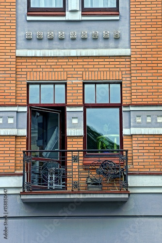 Открытый железный балкон с стеклянной дверью и окном
