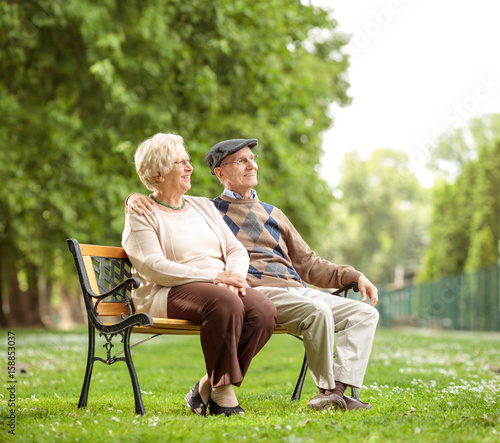 Senior couple sitting on a bench in the park