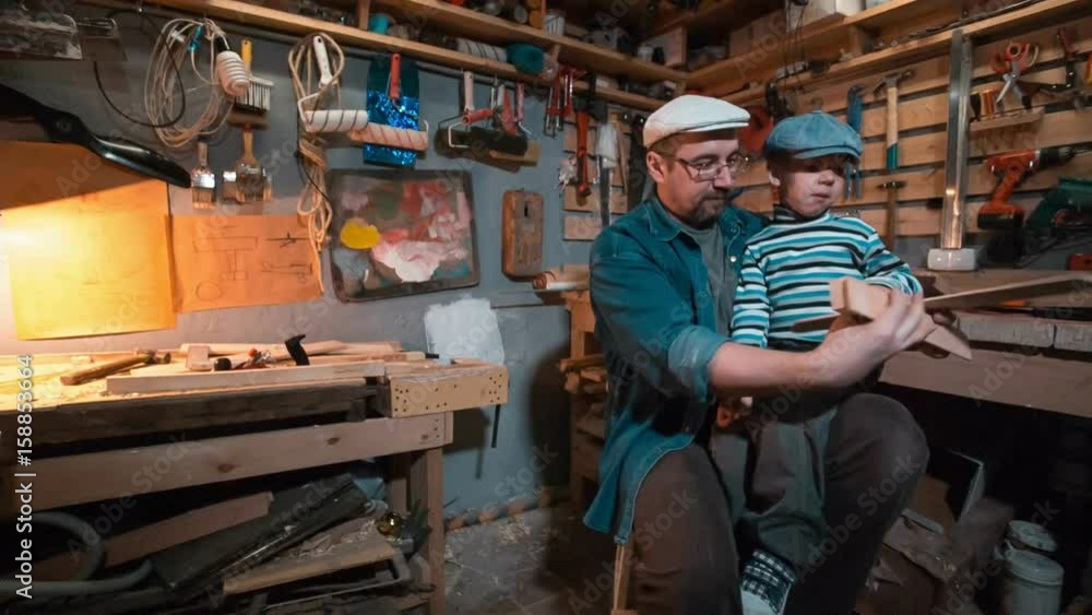 Boy and his dad working at carpenter workroom Boy and his dad working at carpenter workroom