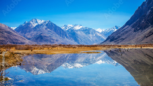 Reflections of Snow mountains in the lake in Diskit, Nubra, Leh, India