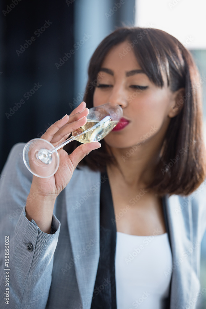 young african american businesswoman drinking champagne from glass young african american businesswoman drinking champagne from glass