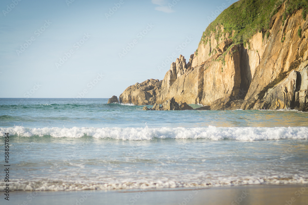 Beautiful beach in the north of Spain, nature of Asturias in warm summer evening during sunset