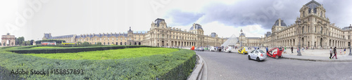 PARIS - JUNE 2014: Tourists walk near Louvre. Paris attracts 30 million tourists annually