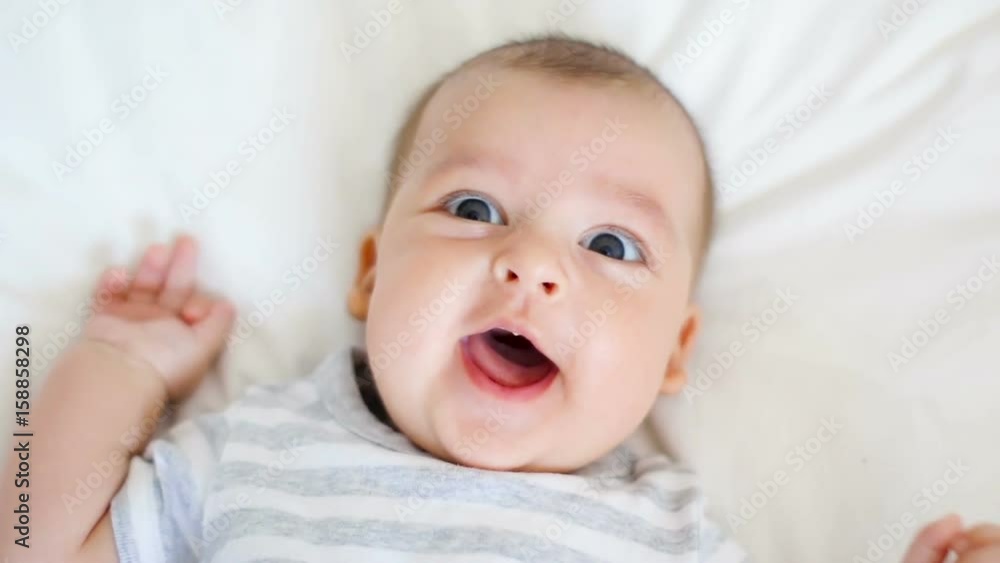 child is happy and laughing lying on bed at home child is happy and laughing lying on bed at home