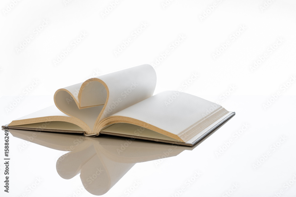 Open book with blank pages folded into heart shape. Open book with blank pages folded into heart shape.