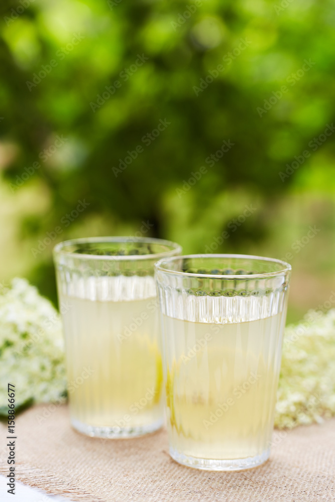 Two glasses with fresh elderflower juice with a slice of lemon Two glasses with fresh elderflower juice with a slice of lemon
