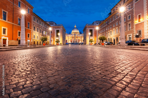 View of The Papal Basilica of St. Peter in the Vatican or Saint Peter Cathedral during morning blue hour in Rome, Italy. © Kavalenkava