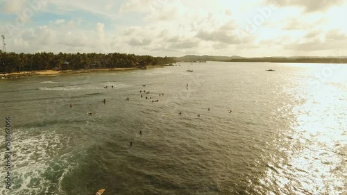 Surfers at siargao islands famous surf break cloud 9 near mindanao the Philippines. Aerial view :People learning to surf at Cloud nine surfpoint in Siargao, Philippines. photo