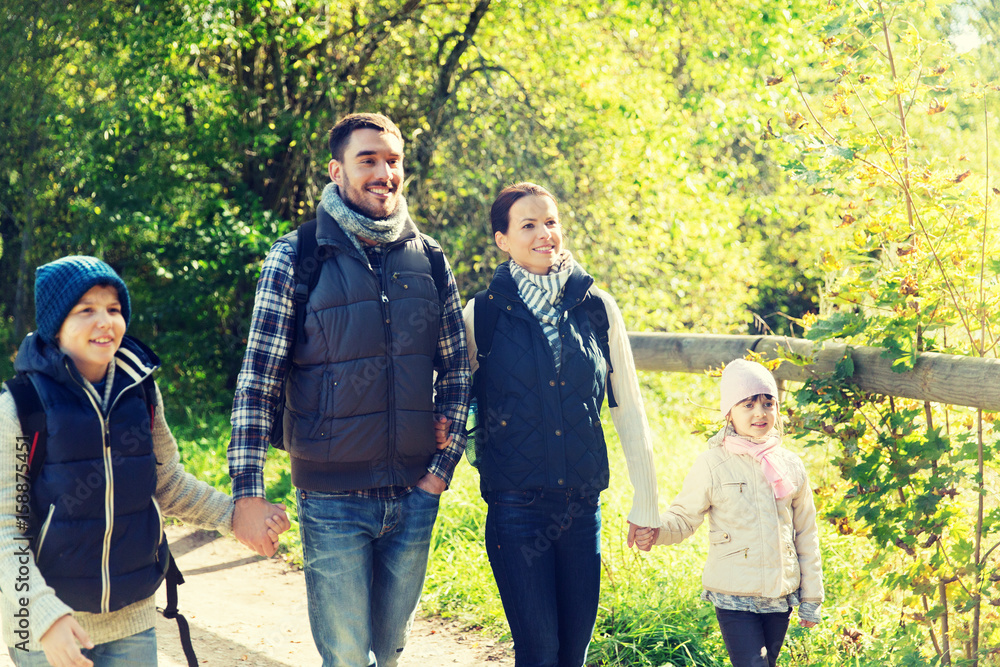 happy family with backpacks hiking in woods happy family with backpacks hiking in woods