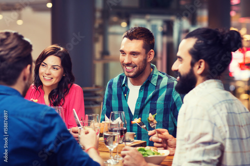 happy friends having dinner at restaurant