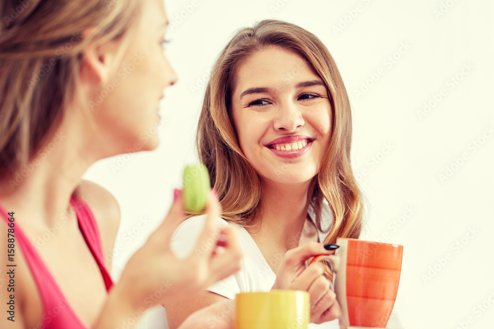 happy young women drinking tea with sweets at home happy young women drinking tea with sweets at home