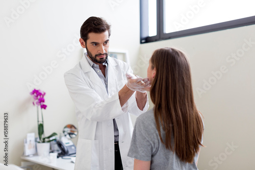 Cosmetic surgeon marking patient's face for surgery photo