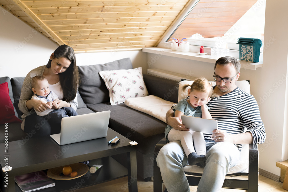Young parents with little children and gadgets at home. Young parents with little children and gadgets at home.