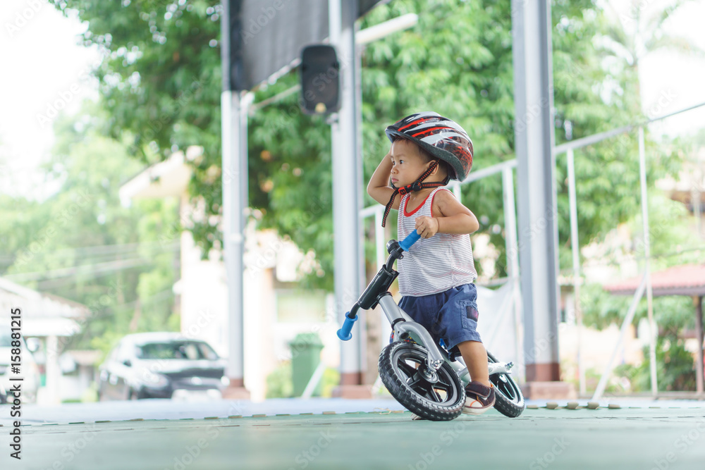 Obraz premium Asian boy is playing with baby balance bike