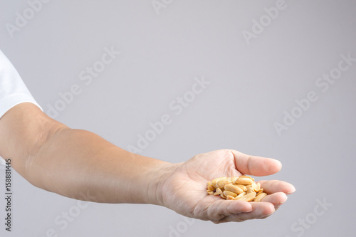 Hand holding heap of salt roasted peanuts