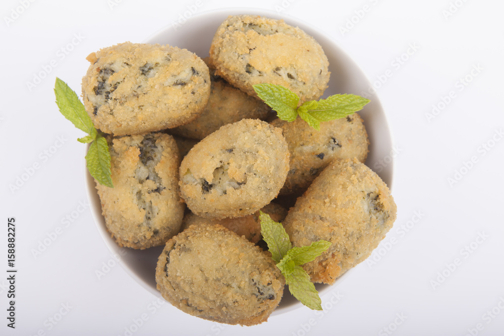 a handful of homemade croquettes of spinach isolated on white a handful of homemade croquettes of spinach isolated on white