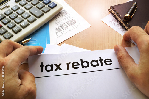 Slika na platnu Hands holding documents with title tax rebate.