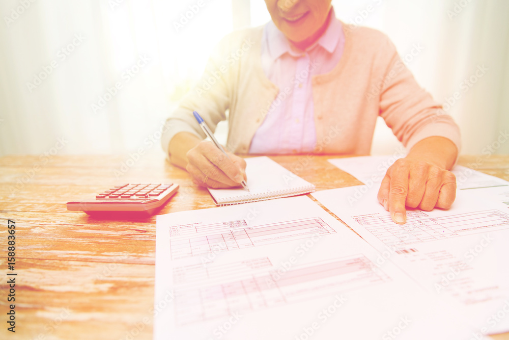 senior woman with papers and calculator at home senior woman with papers and calculator at home