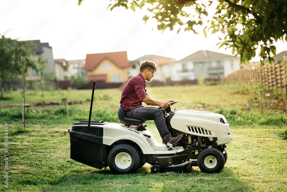 Garnder, man worker cutting grass with lawn mower, lawncare concept. Industrial details Garnder, man worker cutting grass with lawn mower, lawncare concept. Industrial details