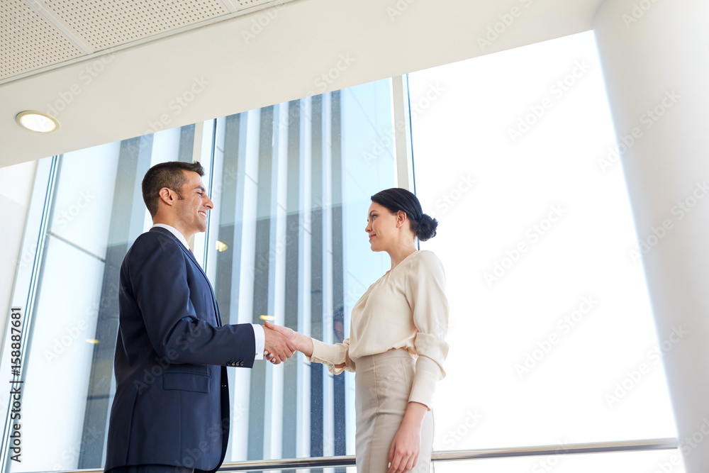 smiling business people shaking hands at office smiling business people shaking hands at office