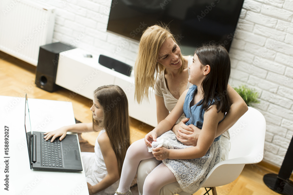 Woman with girls on the laptop at home