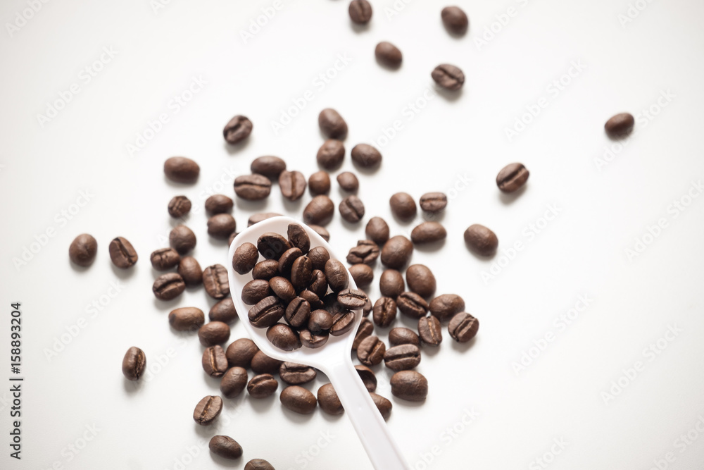 Obraz premium seed coffee and spoon on white background