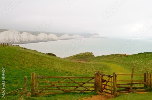 A view to Seven Sisters Cliff in the United Kingdom captured from cattle fence with open door.