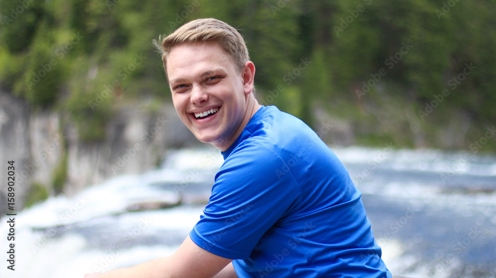 Portrait of Happy Smiling Man with Waterfall in Background