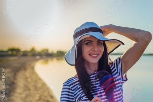 Wallpaper Mural Woman in a hat by the water smiles Torontodigital.ca