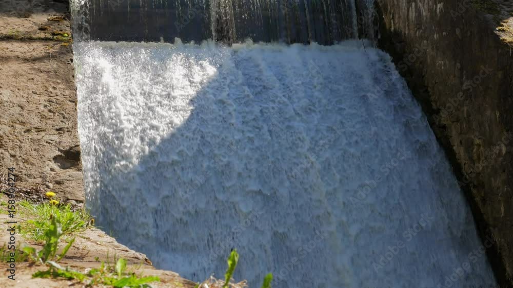 Spillway on the river. The flow of water falls down Spillway on the river. The flow of water falls down