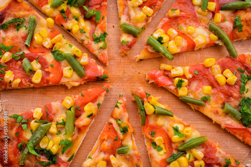 Sliced fresh pizza on wooden background close up photo